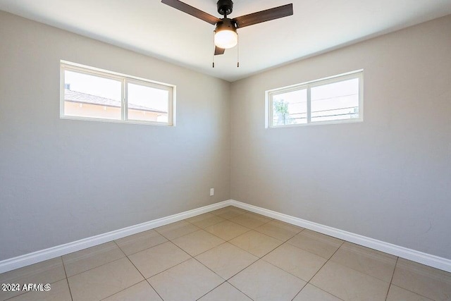 spare room with ceiling fan and light tile patterned floors