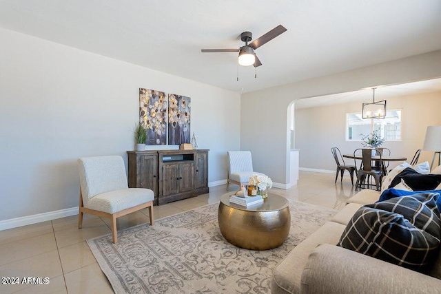 tiled living room featuring ceiling fan with notable chandelier