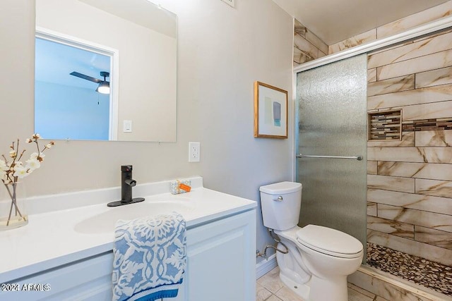 bathroom featuring ceiling fan, toilet, tile patterned flooring, vanity, and a shower with shower door