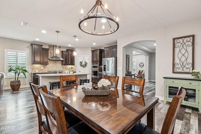 dining area with an inviting chandelier and dark hardwood / wood-style flooring