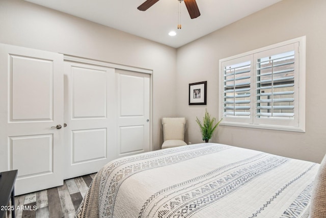 bedroom with hardwood / wood-style floors, a closet, and ceiling fan