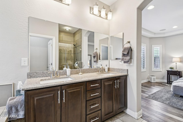 bathroom featuring a shower with door, vanity, a raised ceiling, and hardwood / wood-style floors