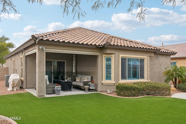 back of house featuring an outdoor living space, a patio area, and a lawn