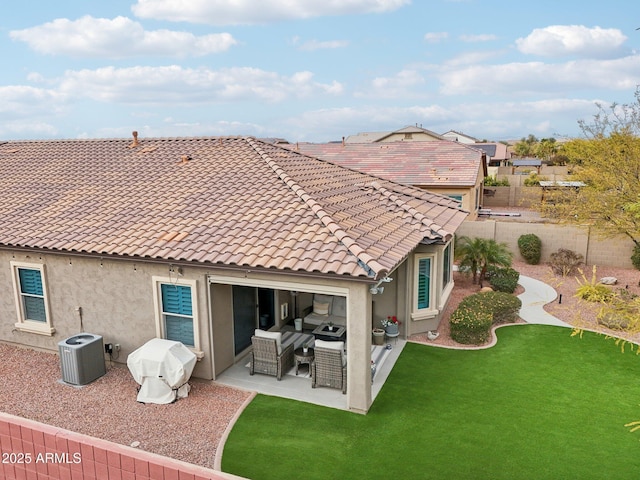 rear view of property with an outdoor living space, a yard, central AC, and a patio