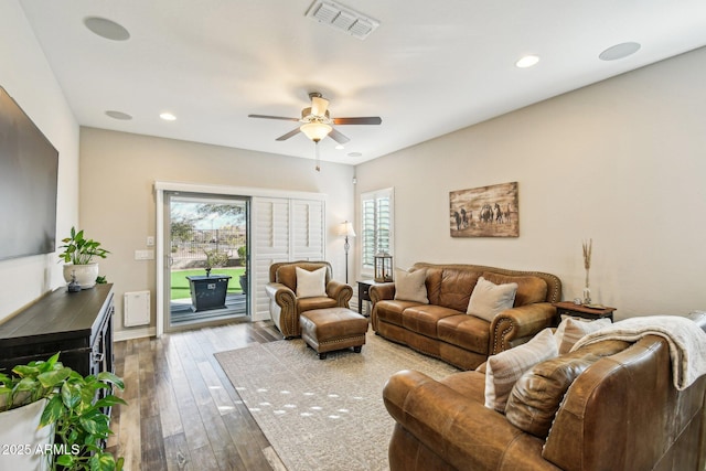 living room featuring wood-type flooring and ceiling fan