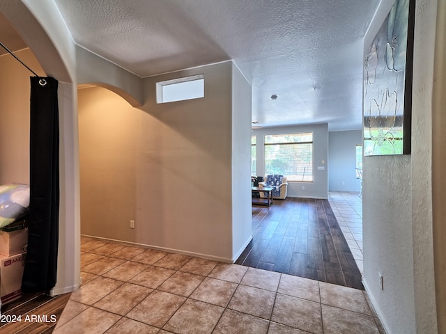 hall with a textured ceiling and hardwood / wood-style flooring