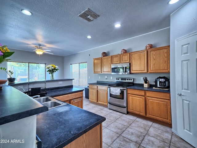 kitchen with a wealth of natural light, ceiling fan, sink, and appliances with stainless steel finishes