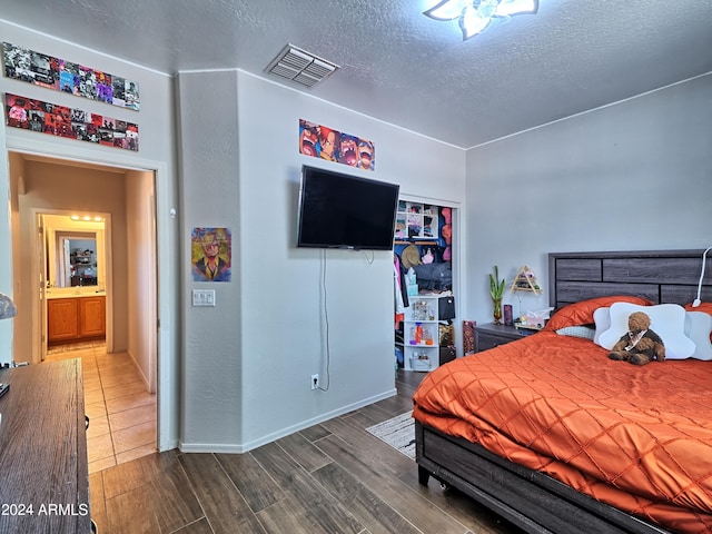 bedroom with a textured ceiling and hardwood / wood-style flooring