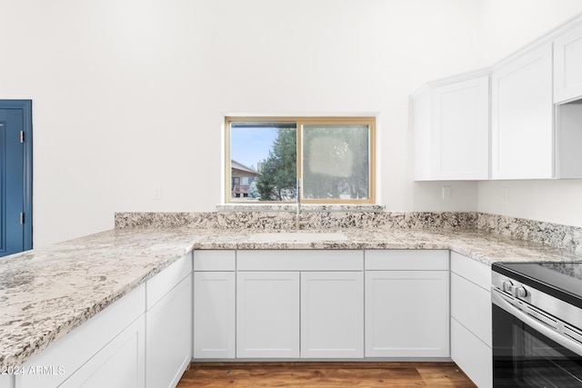 kitchen featuring sink, electric stove, light stone countertops, light hardwood / wood-style floors, and white cabinets