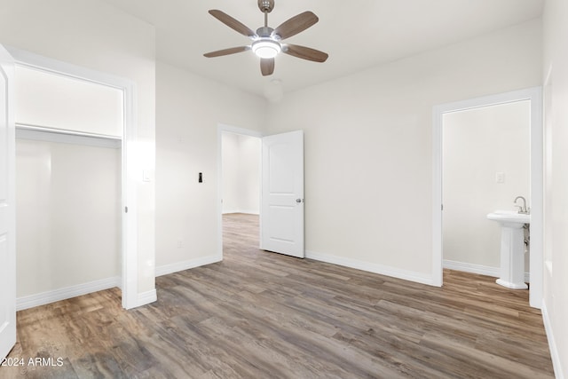 unfurnished bedroom featuring hardwood / wood-style floors, ceiling fan, and a closet