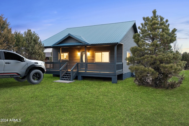 view of front of property featuring a wooden deck and a yard