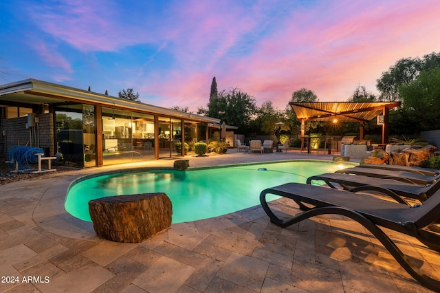 pool at dusk with a patio