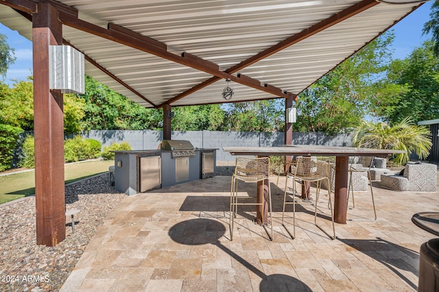 view of patio with an outdoor kitchen and a grill