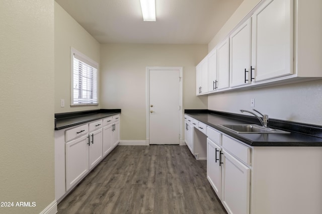 kitchen featuring sink, wood-type flooring, and white cabinetry