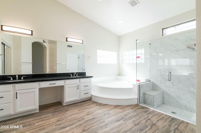 bathroom featuring plus walk in shower, vaulted ceiling, and vanity