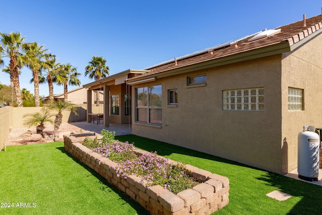 back of property with a patio area and a yard