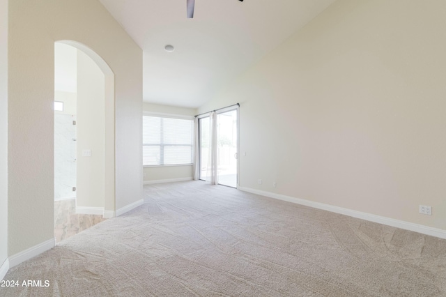 carpeted empty room with ceiling fan and vaulted ceiling