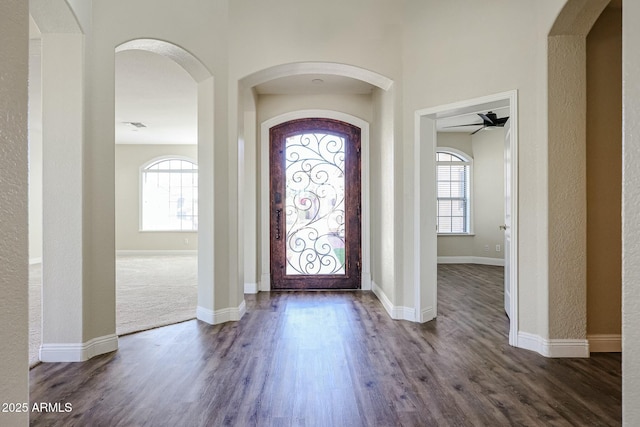 entrance foyer with ceiling fan and dark wood-type flooring