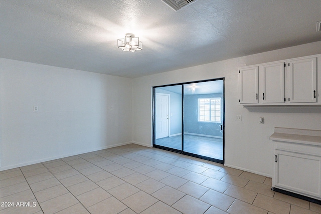 3115 N 55th Ave, Phoenix, AZ 85031 - unfurnished dining area featuring a textured ceiling and light tile patterned flooring