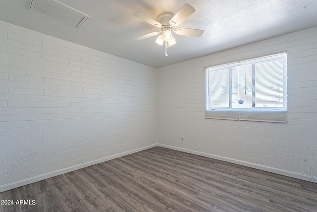 3115 N 55th Ave, Phoenix, AZ 85031 - empty room featuring dark wood finished floors, brick wall, and ceiling fan