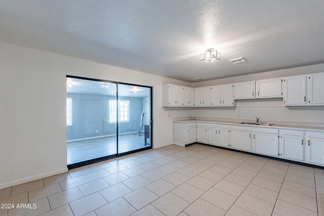3115 N 55th Ave, Phoenix, AZ 85031 - kitchen featuring light countertops, white cabinetry, and light tile patterned flooring