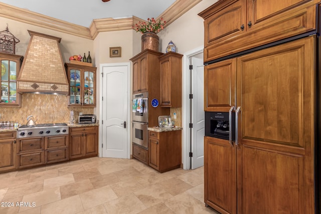 kitchen with light stone countertops, crown molding, premium range hood, and appliances with stainless steel finishes