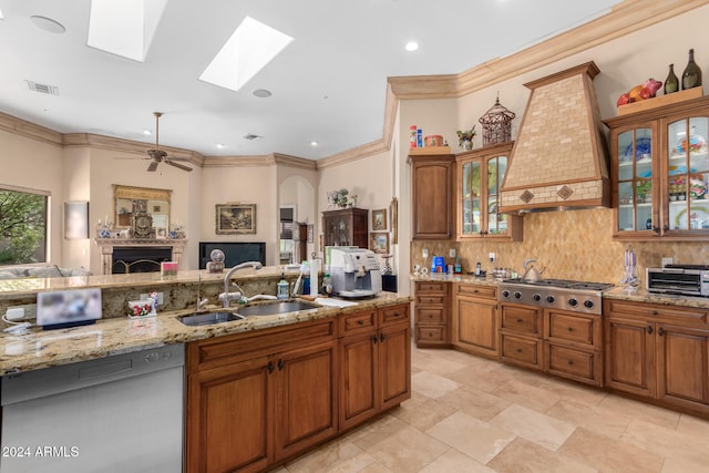 kitchen featuring sink, custom exhaust hood, ceiling fan, crown molding, and appliances with stainless steel finishes