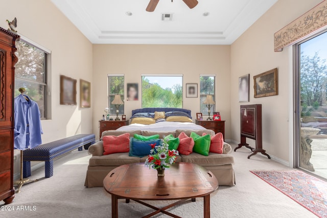 bedroom with ceiling fan, access to exterior, light carpet, and a raised ceiling