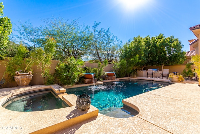 view of swimming pool featuring a patio area and an in ground hot tub