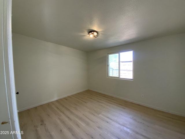 unfurnished room featuring light hardwood / wood-style floors and a textured ceiling