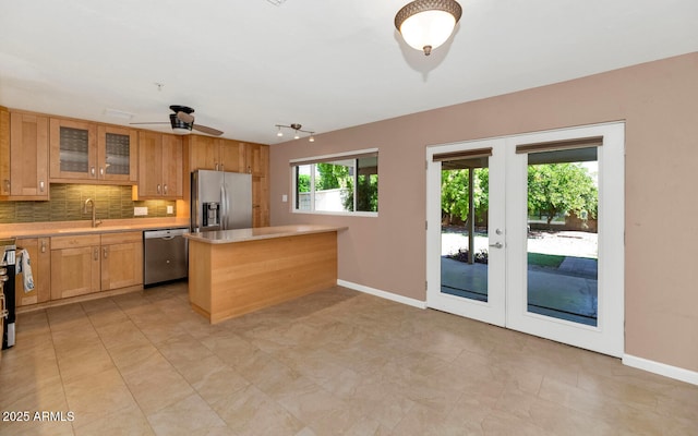 8140 E Mitchell Dr, Scottsdale, AZ 85251 - kitchen with stainless steel appliances, french doors, light countertops, backsplash, and glass insert cabinets