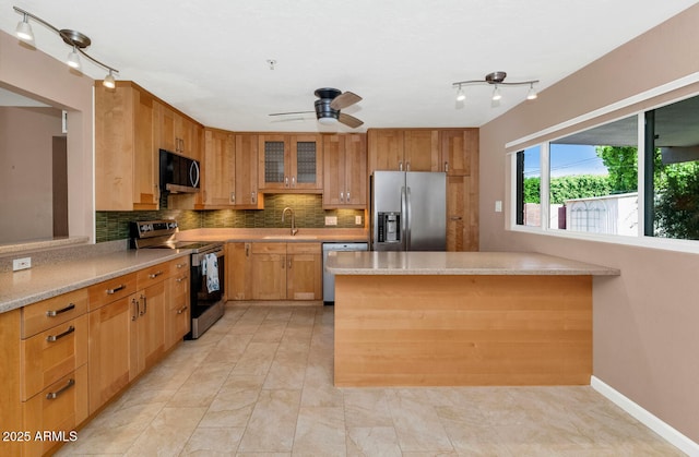 8140 E Mitchell Dr, Scottsdale, AZ 85251 - kitchen with stainless steel appliances, tasteful backsplash, rail lighting, ceiling fan, and a peninsula