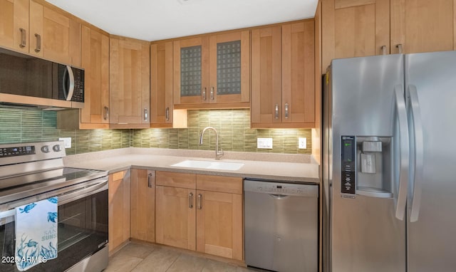 8140 E Mitchell Dr, Scottsdale, AZ 85251 - kitchen with stainless steel appliances, light countertops, backsplash, glass insert cabinets, and light tile patterned floors