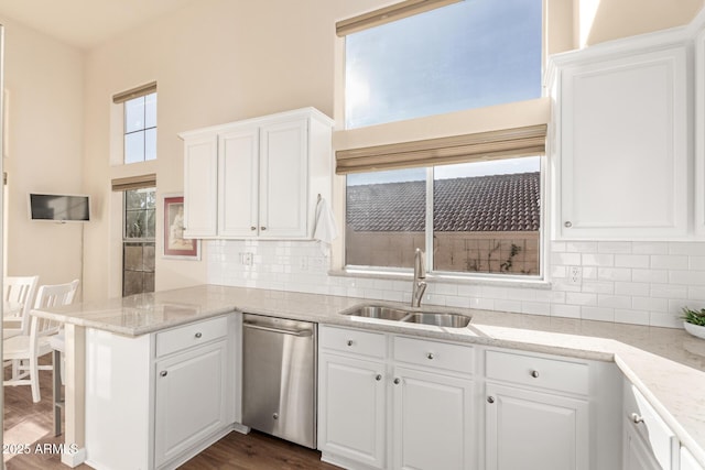 kitchen featuring kitchen peninsula, dark wood-type flooring, dishwasher, white cabinets, and sink