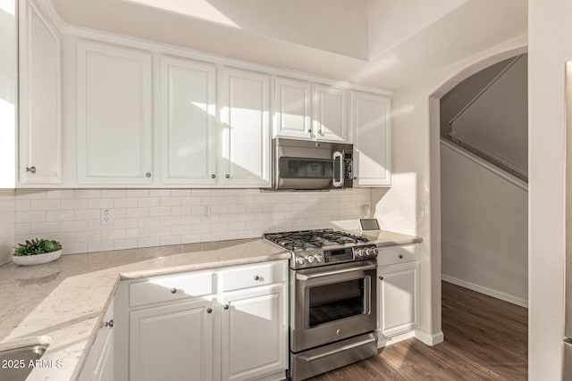 kitchen with white cabinets, appliances with stainless steel finishes, and light stone countertops