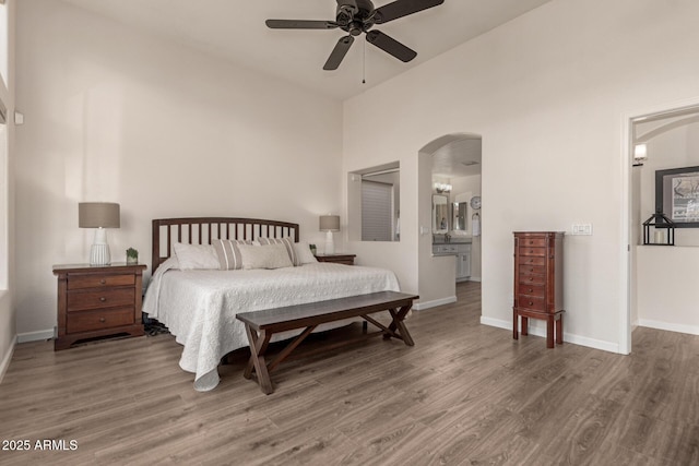 bedroom with ensuite bath, high vaulted ceiling, ceiling fan, and hardwood / wood-style flooring