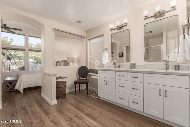 bathroom with ceiling fan, a shower, vanity, and wood-type flooring