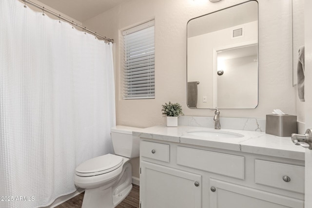 bathroom with toilet, hardwood / wood-style flooring, and vanity