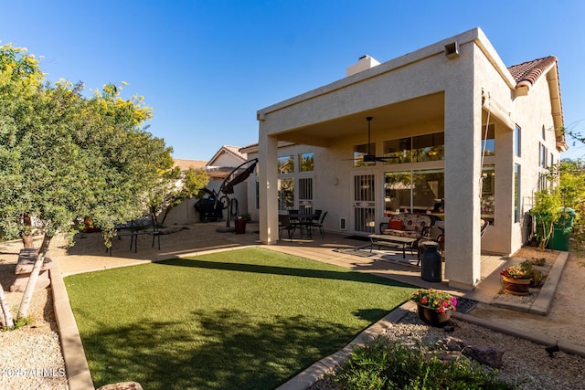 rear view of house with a patio area, ceiling fan, and a yard