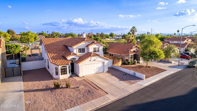 4049 E Arbor Ave, Mesa, AZ 85206 - mediterranean / spanish-style home with stucco siding, a garage, a gate, driveway, and a tiled roof