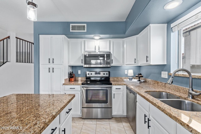 4049 E Arbor Ave, Mesa, AZ 85206 - kitchen with stainless steel appliances, a sink, white cabinets, light stone countertops, and pendant lighting
