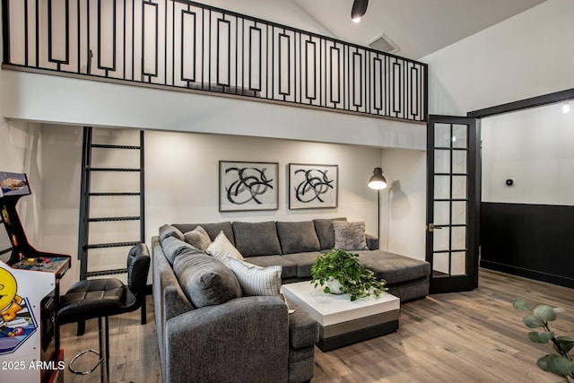 living room featuring wood-type flooring and high vaulted ceiling