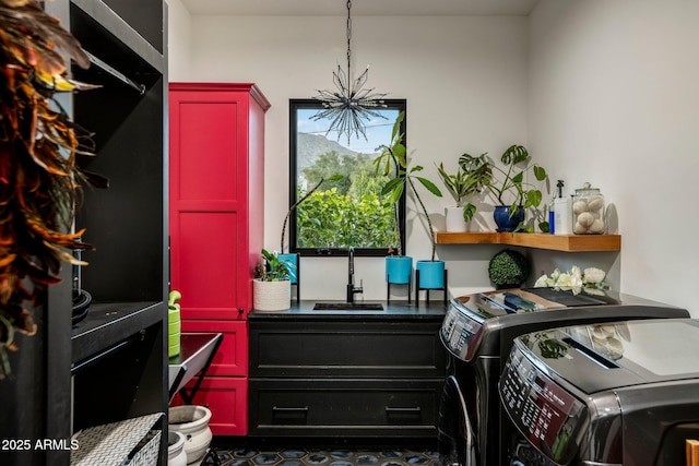 laundry area featuring washer and dryer, sink, and a notable chandelier