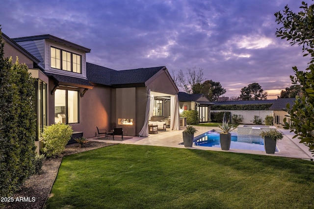 back house at dusk with a fenced in pool, a yard, and a patio area