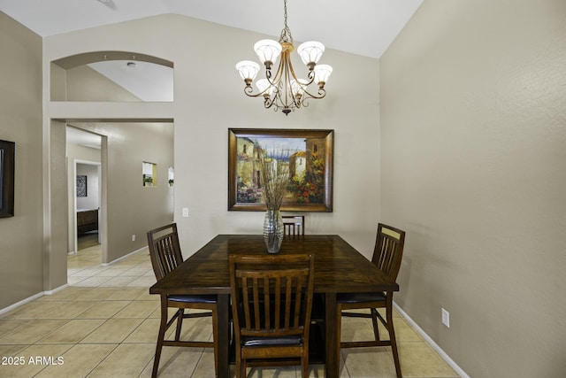 dining space with light tile patterned floors, high vaulted ceiling, a notable chandelier, and baseboards