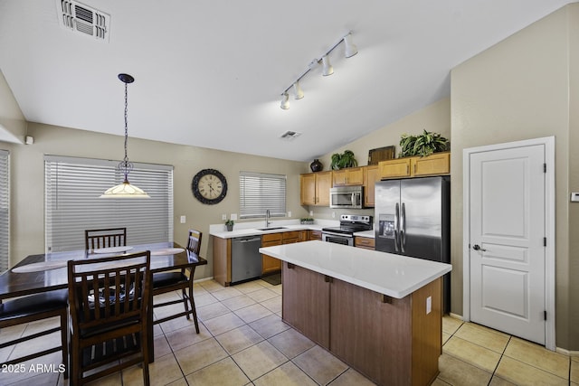 kitchen with a sink, visible vents, light countertops, appliances with stainless steel finishes, and lofted ceiling