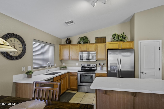 kitchen with appliances with stainless steel finishes, light countertops, a sink, visible vents, and lofted ceiling