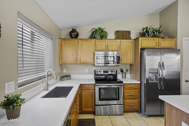 kitchen featuring light tile patterned flooring, appliances with stainless steel finishes, light countertops, and a sink