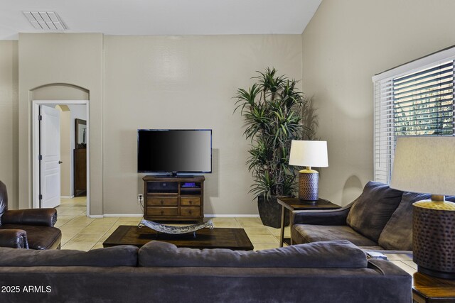 living room featuring light tile patterned flooring, visible vents, and baseboards