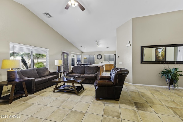living area with light tile patterned floors, baseboards, visible vents, a ceiling fan, and high vaulted ceiling